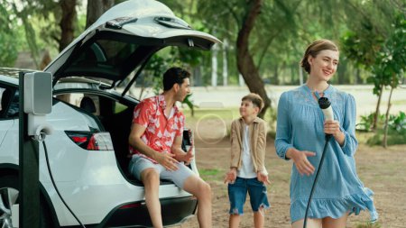 Photo for Family road trip vacation with electric vehicle, lovely family recharge EV car with green and clean energy. Natural and eco friendly car travel for sustainable environment. Perpetual - Royalty Free Image