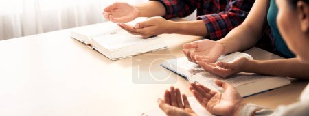 Photo for Cropped image of diversity people hand praying together at wooden church on bible book. Group of believer hold hand together faithfully. Concept of hope, religion, faith, god blessing. Burgeoning. - Royalty Free Image
