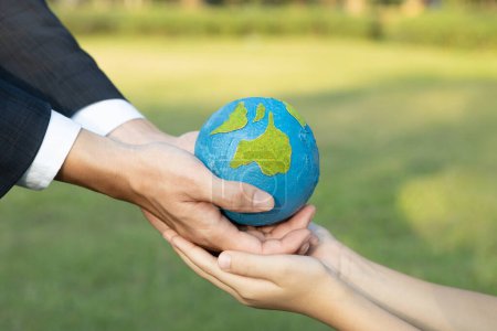 Photo for Businessman hand giving Earth globe to little boy as Earth day concept as corporate social responsible to contribute greener environmental protection for sustainable future generation. Gyre - Royalty Free Image