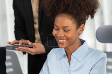 Téléchargez les photos : Jeune femme d'affaires africaine travaillant ensemble et discutant dans un bureau d'entreprise avec des collègues multiculturels. Travail d'équipe professionnel et diversité discuter du plan d'affaires sur place. Concord - en image libre de droit