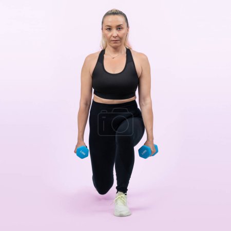 Photo for Full body length shot active and sporty senior woman lifting dumbbell during weight training workout on isolated background. Healthy active physique and body care lifestyle for pensioner. Clout - Royalty Free Image