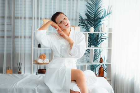 Photo for Serene modern daylight ambiance of spa salon, woman customer posing and indulges in rejuvenating with facial skincare mask. Facial skin treatment and beauty cosmetology procedure for face. Quiescent - Royalty Free Image
