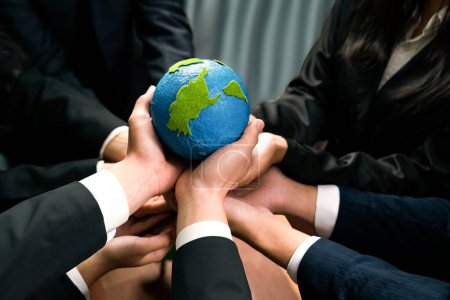 Photo for Top view business people holding Earth together in synergy as team building to utilize eco regulation for environmental protection by reducing CO2 emission to save Earth. Quaint - Royalty Free Image