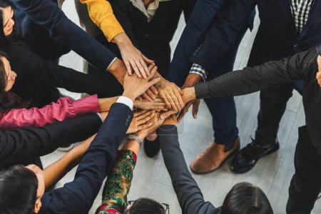 Eine Gruppe von Diversitätsmenschen, die ihre Hände zusammenlegen. Zeigt Einheit, Teamwork und Freundschaft. Nahaufnahme von oben, wie ein junger Geschäftsmann und eine Geschäftsfrau als Team zusammenarbeiten. Intellektuelle.