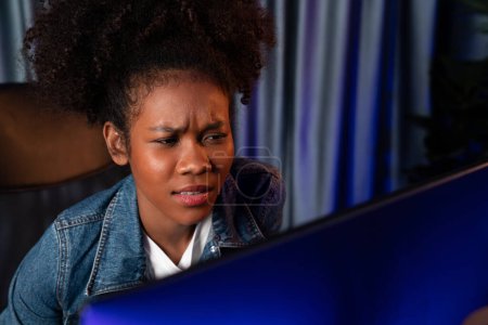 Photo for Young African American creator woman with serious face, thinking carefully and looking at final project document on laptop for planing next sequence. Concept of work at neat home place. Tastemaker. - Royalty Free Image