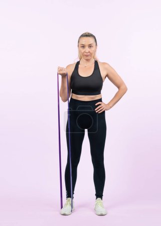 Photo for Full body length shot athletic and sporty senior woman with fitness resistance band on isolated background. Healthy active physique and body care lifestyle after retirement. Clout - Royalty Free Image