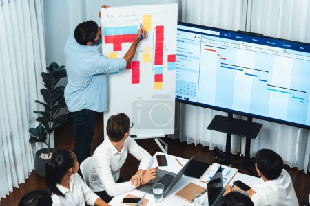 Photo for Project manager communicate and collaborate with team using project management software display on monitor, tracking progress of project task and making schedule plan at meeting table. Prudent - Royalty Free Image