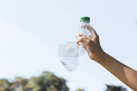 Foto de Botella de plástico reciclable sostenida en la mano sobre el fondo del cielo. Los residuos plásticos de mano para reciclar reducen y reutilizan el concepto para promover un medio ambiente limpio con una gestión eficaz del reciclaje. Gyre. - Imagen libre de derechos
