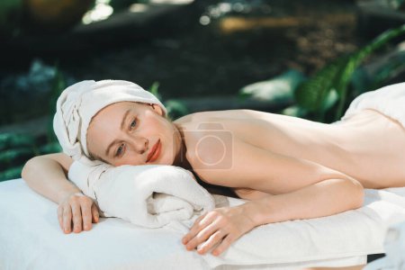 Foto de Retrato de mujeres caucásicas jóvenes atractivas con hermosa piel se encuentra en la cama de spa mientras espera el masaje corporal rodeado de un ambiente natural relajante. Concepto saludable y de belleza. Tranquilidad. - Imagen libre de derechos