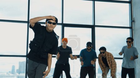 Photo for Multicultural hipster group looking at camera while perform break dancing at building with sky scrapper or city view. Street dancer team looking at dancer performance. Outdoor sport 2024. Endeavor. - Royalty Free Image
