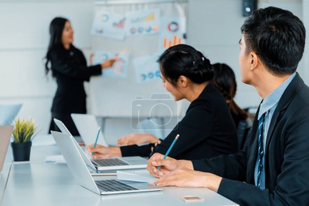 Photo for Asian business people listening to presentation from businesswoman who stands in front of group meeting room at international business conference. Multicultural corporate strategy concept. uds - Royalty Free Image