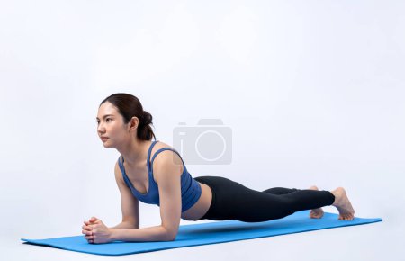 Foto de Ajuste joven asiática mujer planeando en la esterilla de ejercicio. Rutina de entrenamiento de estilo de vida saludable en antecedentes aislados. Equilibrio y resistencia ejerciendo el concepto. Vigoroso - Imagen libre de derechos