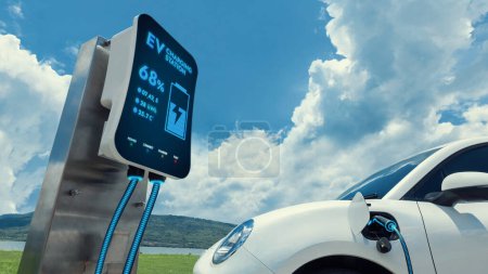 Photo for Electric car plugged in with charging station to recharge battery by EV charger cable with nature vacation background. Future innovative ev car and energy sustainability. Peruse - Royalty Free Image