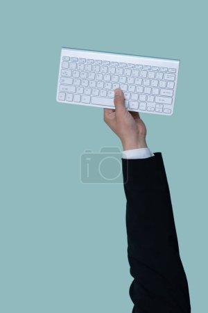 Photo for Hand holding wireless keyboard on isolated background for start up tech company. Eco-friendly green business promoting electronic waste policy idea. Quaint - Royalty Free Image