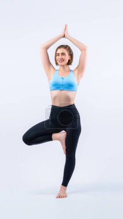 Photo for Full body length gaiety shot athletic and sporty woman doing healthy and meditative yoga exercise workout posture on isolated background. Healthy active and body care lifestyle - Royalty Free Image