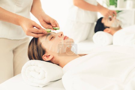Photo for Serene daylight ambiance of spa salon, couple customer indulges in rejuvenating with luxurious cucumber facial mask. Facial skincare treatment and beauty care concept. Quiescent - Royalty Free Image