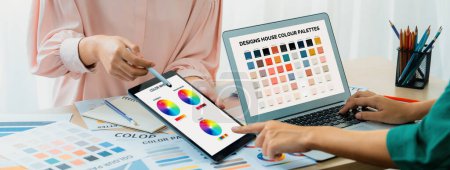 Photo for A cropped picture of professional designer selects the color by using color theory while using laptop compare the color on table with designing material and equipment scatter around. Variegated. - Royalty Free Image