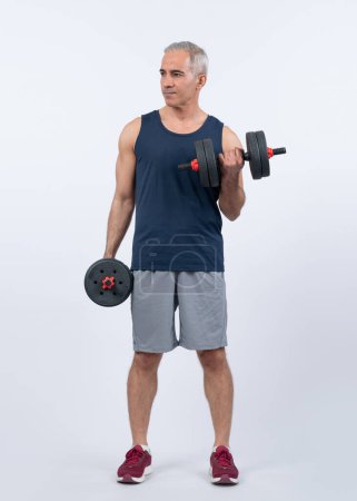 Photo for Full body length shot active and sporty senior man lifting dumbbell during weight training workout on isolated background. Healthy active physique and body care lifestyle for pensioner. Clout - Royalty Free Image