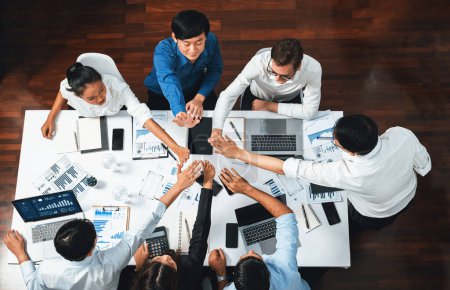 Photo for Top view diverse office worker join hand together in office room symbolize business synergy and strong productive teamwork in workplace. Cooperation and unity between business employee. Prudent - Royalty Free Image