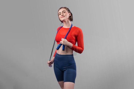 Photo for Full body length gaiety shot athletic and sporty young woman with fitness skipping rope in standing posture on isolated background. Healthy active and body care lifestyle. - Royalty Free Image