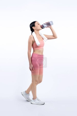 Foto de Mujer asiática atlética y deportiva descansando y bebiendo agua después de un entrenamiento intensivo de cardio. Ejercicio saludable y la búsqueda de estilo de vida de cuidado corporal en estudio tiro fondo aislado. Vigoroso - Imagen libre de derechos