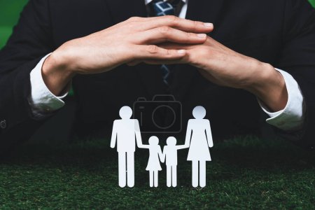 Téléchargez les photos : Contexte de papier icône de la famille tenue en main symbolisent le dévouement à un mode de vie respectueux de l'environnement de la famille moderne, la parentalité guidant un mode de vie durable pour leurs enfants. Pneumatique - en image libre de droit
