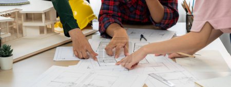 Photo for Experienced architects and engineers collaborate on house design and construction. Skilled interior design team discuss about house structure while project manager pointing at blueprint. Burgeoning. - Royalty Free Image