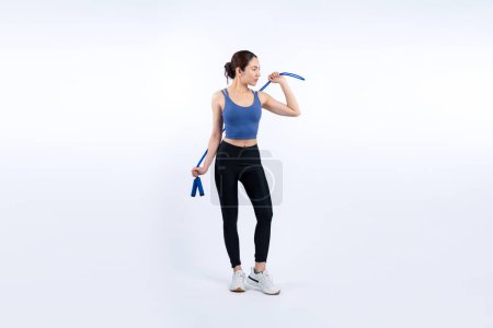 Photo for Young energetic asian woman in sportswear with jumping or skipping robe posing portrait in studio shot on isolated background. Cardio exercise tool and healthy body care lifestyle. Vigorous - Royalty Free Image