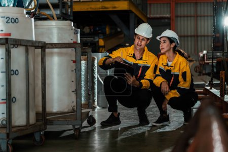 Foto de Dos trabajadores o ingenieros de fábrica realizan una inspección profesional de la máquina o el procedimiento en la planta química, el lugar de trabajo de la fábrica química y el concepto de profesión industrial. Ejemplificando - Imagen libre de derechos