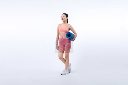 Foto de Joven mujer asiática atractiva retrato en ropa deportiva con colchoneta de ejercicio. Ejercicio saludable y ejercicio concepto de rutina de estilo de vida. Estudio filmó fondo aislado. Vigoroso - Imagen libre de derechos