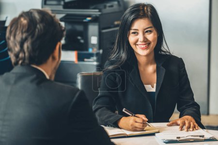 Photo for Businesswoman from human resources department is interviewing businessman candidate for job application in meeting room while considering his CV resume document. Employee hiring business concept. uds - Royalty Free Image