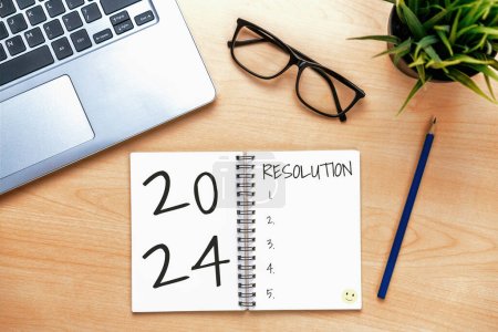 2024 Happy New Year Resolution Goal List and Plans Setting - Bureau d'affaires avec un cahier écrit sur la liste des objectifs et des résolutions du nouvel an. Changement et félicité concept.