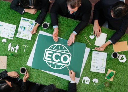 Foto de Vista superior del símbolo panorámico ECO en la mesa de césped verde con gente de negocios que planea la utilización de energía alternativa para una Tierra sostenible más ecológica como responsabilidad social corporativa. Pintoresco - Imagen libre de derechos