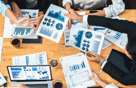 Photo for Top view diverse group of business analyst team analyzing financial data report paper on meeting table. Chart and graph dashboard by business intelligence analysis. Meticulous - Royalty Free Image
