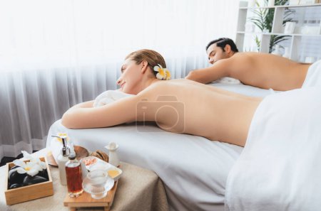 Photo for Caucasian couple customer enjoying relaxing anti-stress spa massage and pampering with beauty skin recreation leisure in day light ambient salon spa at luxury resort or hotel. Quiescent - Royalty Free Image