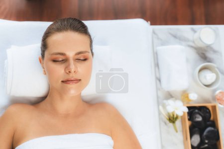 Téléchargez les photos : Panorama vue de dessus femme client appréciant relaxant massage spa anti-stress et dorloter avec beauté loisirs de la peau dans la lumière du jour salon spa ambiant au complexe de luxe ou hôtel. Tranquillité - en image libre de droit