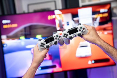 Photo for Close up photo of holding joystick crashing or cheerful friends on car racing competition of video game on blurred screen. Concept of lifestyles gamer on weekend with friend in living room. Sellable. - Royalty Free Image