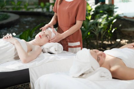 Photo for A portrait of two caucasian woman with beautiful skin having facial massage while falling the deep state of relaxation surrounded by outdoor natural and peaceful environment. Tranquility. - Royalty Free Image