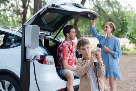 Photo for Family road trip vacation with electric vehicle, lovely family recharge EV car with green and clean energy. Natural and eco friendly car travel for sustainable environment. Perpetual - Royalty Free Image