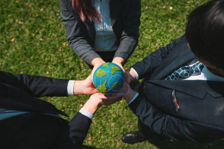 Photo for Group of business people hold planet Earth globe together as Earth day concept. Mission to save Earth by business commitment to environment friendly methods and sustainable practices. Gyre - Royalty Free Image