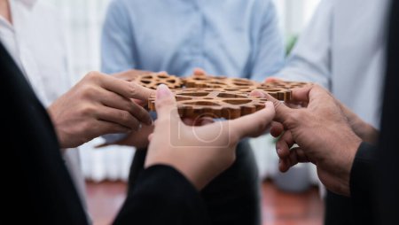 Photo for Office worker holding cog wheel as unity and teamwork in corporate workplace concept. Diverse colleague business people showing symbol of visionary system and mechanism for business success. Concord - Royalty Free Image