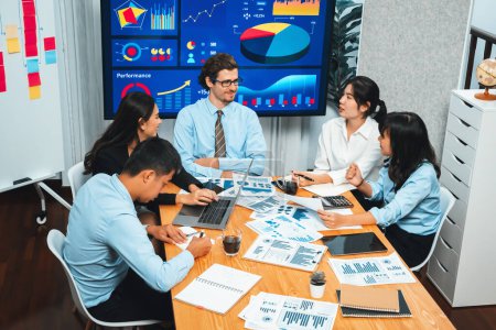 Photo for Diverse group of business analyst team analyzing financial data report. Finance data analysis chart and graph dashboard show on TV screen in meeting room for strategic marketing planning. Habiliment - Royalty Free Image