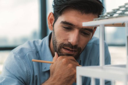 Photo for Closeup portrait of smart caucasian engineer face inspect house model while thinking about building construction at architect studio. Pointing pencil. Creative design, civil engineering. Tracery. - Royalty Free Image