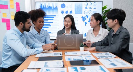 Photo for Multiracial analyst team use BI Fintech software to analyze financial data on meeting table. Financial dashboard data display on laptop screen with analyzed chart for marketing indication. Concord - Royalty Free Image