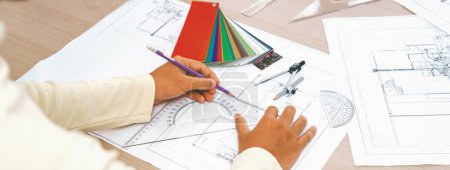 Photo for Cropped image of professional architect designer hand draws blueprint while project manager shows the mistake point with architectural document, color palette scatter around. Closeup. Variegated. - Royalty Free Image