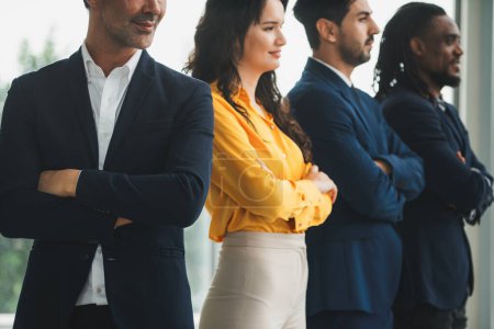 Photo for A diverse group of candidates stands together with arms crossed, confident and determined. A Successful businesswoman and her smart team smiling. Cropped side view. Office uniform. Intellectual. - Royalty Free Image