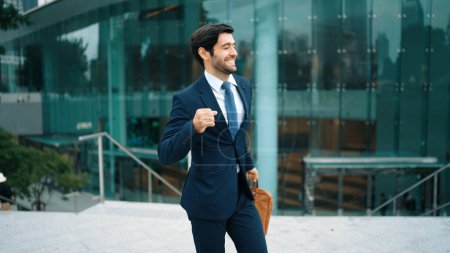Photo for Successful business man celebrate for getting promotion while walking to office. Caucasian receive good news about sales increase or successful project. Manager feel overjoy and happy. Exultant. - Royalty Free Image
