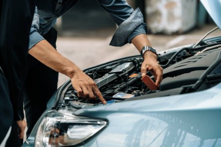 Photo for Man help woman fix the car problem. He pop up the car hood to repair the damaged part. uds - Royalty Free Image