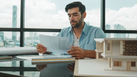Photo for Skilled smart architect engineer writing house construction on blueprint at table with house model, architectural equipment, Interior designer draw, draft, plan building design at office. Disputation - Royalty Free Image