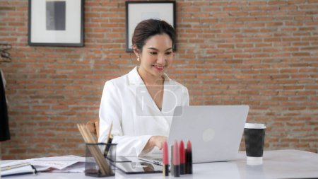 Photo for Young businesswoman sitting on the workspace desk using laptop computer for internet online content writing or secretary remote working from home. Vivancy - Royalty Free Image